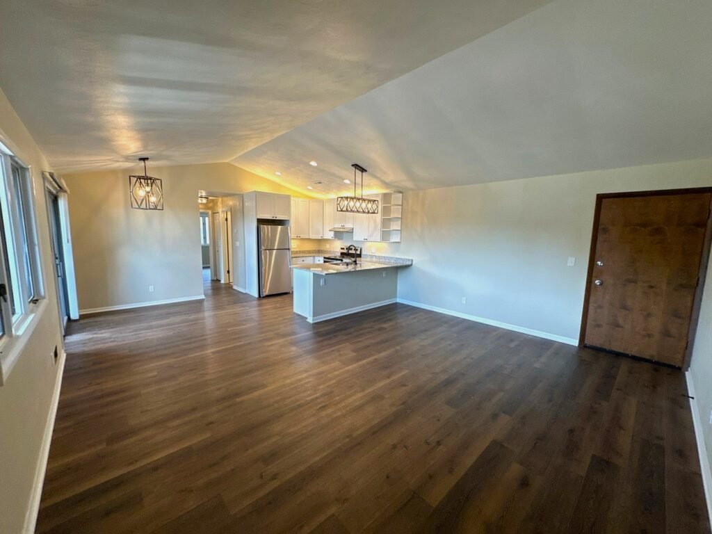 Open-concept Penthouse Suite at Country Club Hills, Steubenville, showing living room connected to kitchen and dining area.